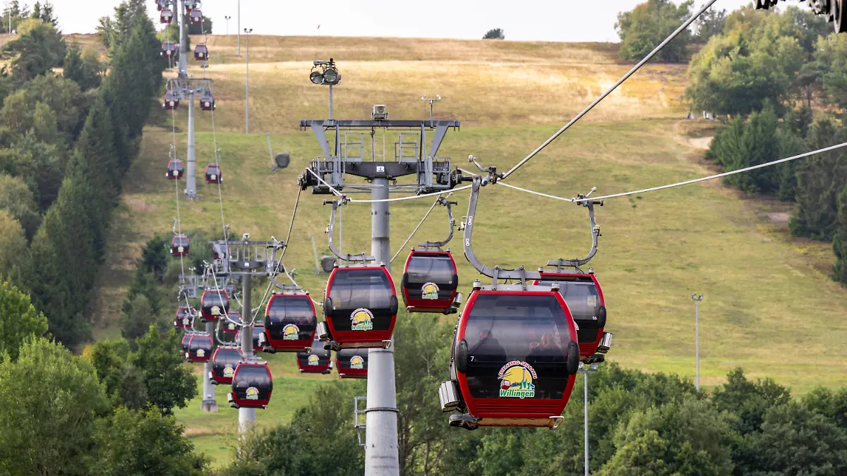 28.08.2022, Hessen, Willingen: Menschen fahren in den Kabinen der Ettelsberg Seilbahn hinauf zum Gipfel. In Hessens Skigebieten laufen die Planungen, wie angesichts der drohenden Energiekrise im Winter Energie eingespart werden kann. Die größten Energiefresser in Willingen sind die bis zu 1500 Meter langen Seilbahnen. Foto: David Inderlied/dpa +++ dpa-Bildfunk +++
