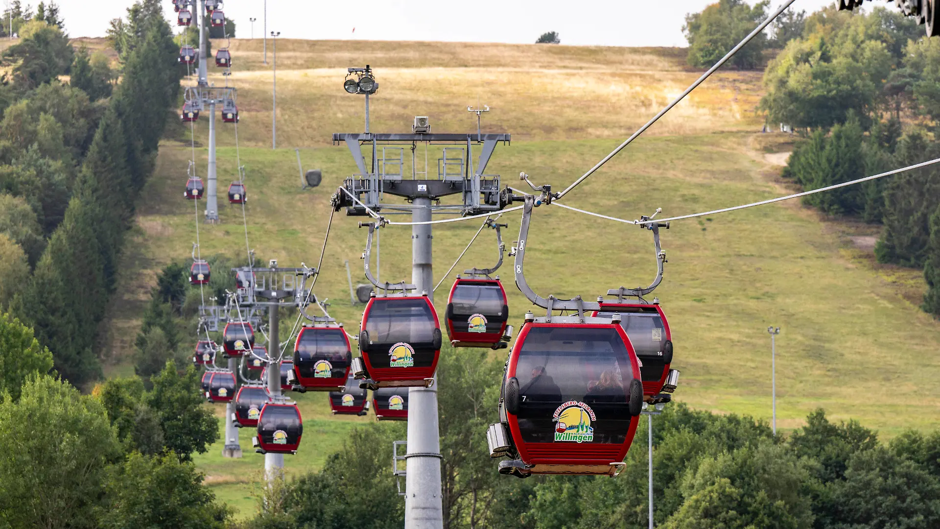 28.08.2022, Hessen, Willingen: Menschen fahren in den Kabinen der Ettelsberg Seilbahn hinauf zum Gipfel. In Hessens Skigebieten laufen die Planungen, wie angesichts der drohenden Energiekrise im Winter Energie eingespart werden kann. Die größten Energiefresser in Willingen sind die bis zu 1500 Meter langen Seilbahnen. Foto: David Inderlied/dpa +++ dpa-Bildfunk +++