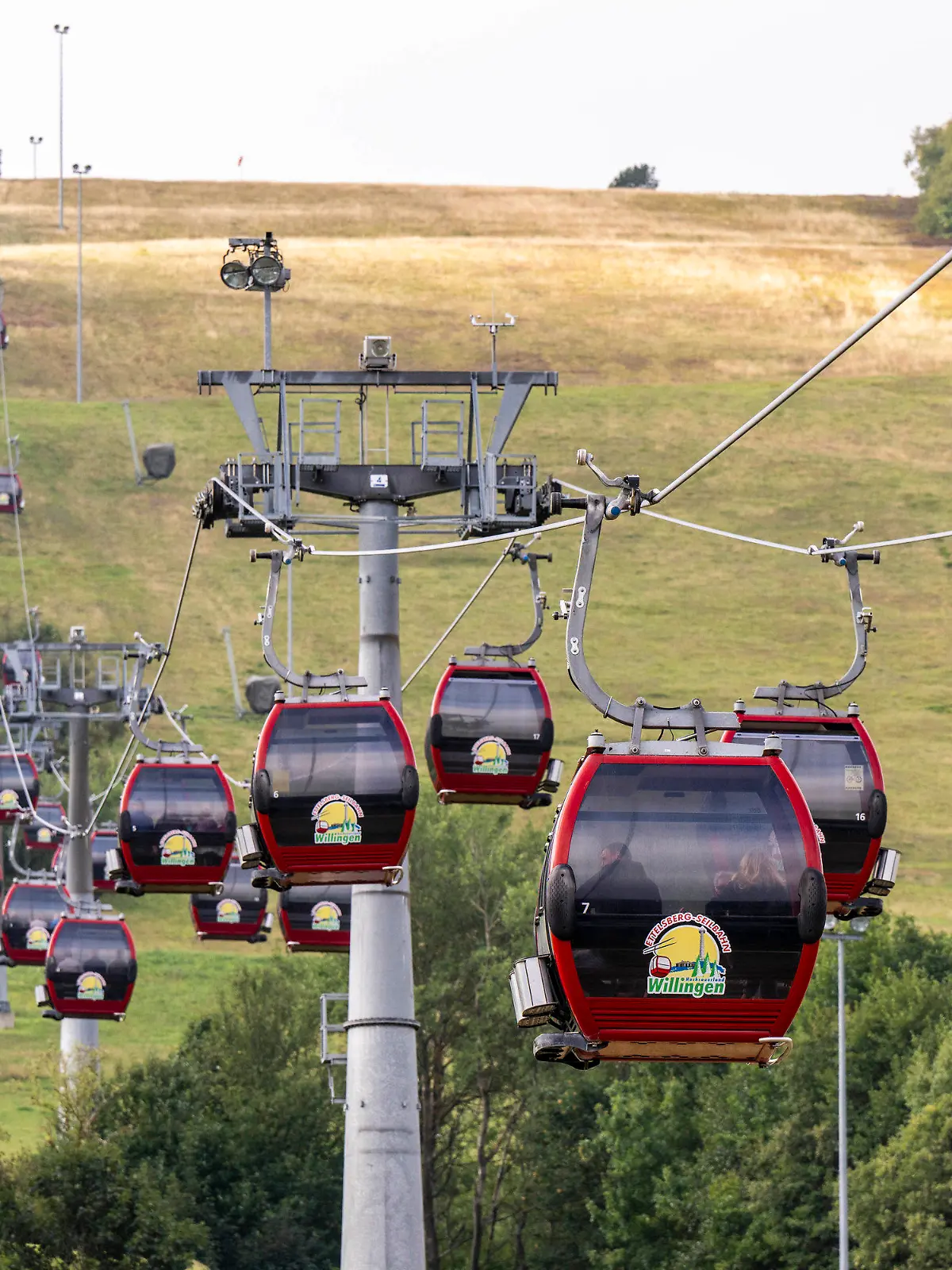 28.08.2022, Hessen, Willingen: Menschen fahren in den Kabinen der Ettelsberg Seilbahn hinauf zum Gipfel. In Hessens Skigebieten laufen die Planungen, wie angesichts der drohenden Energiekrise im Winter Energie eingespart werden kann. Die größten Energiefresser in Willingen sind die bis zu 1500 Meter langen Seilbahnen. Foto: David Inderlied/dpa +++ dpa-Bildfunk +++