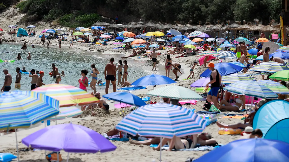 14.08.2022, Spanien, Capdepera: Menschen schwimmen und sonnen sich am Strand Cala Ratjada auf Mallorca. Noch immer herrschen hier hohe Temperaturen und Hitzewarnungen. Foto: Clara Margais/dpa +++ dpa-Bildfunk +++