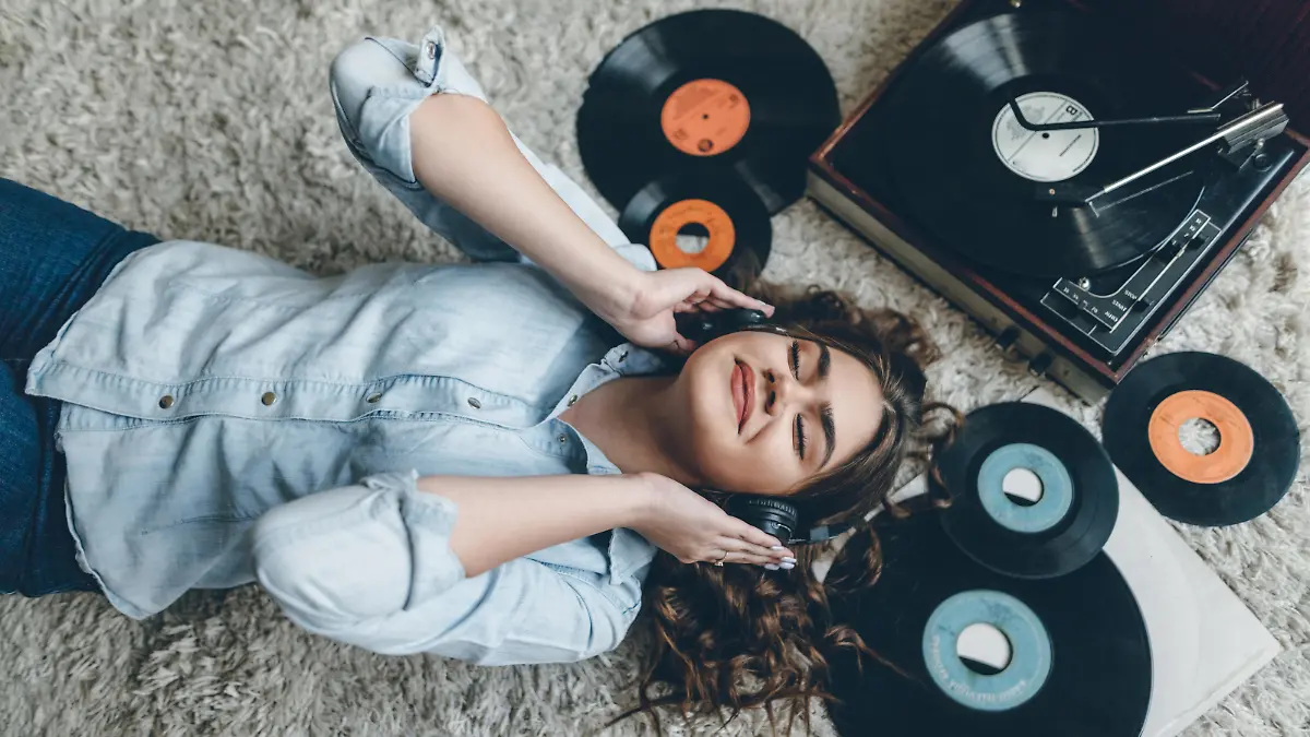 Young retro woman listening music on floor