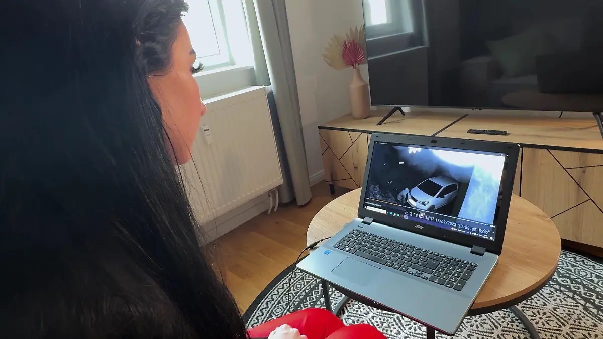 Eine Frau sitzt vor einem Laptop und schaut sich Überwachungsvideos an.