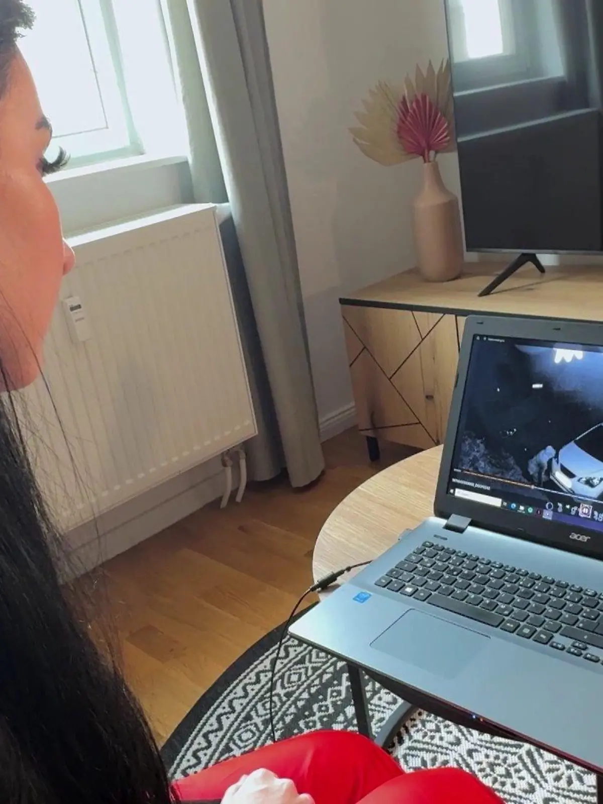 Eine Frau sitzt vor einem Laptop und schaut sich Überwachungsvideos an.