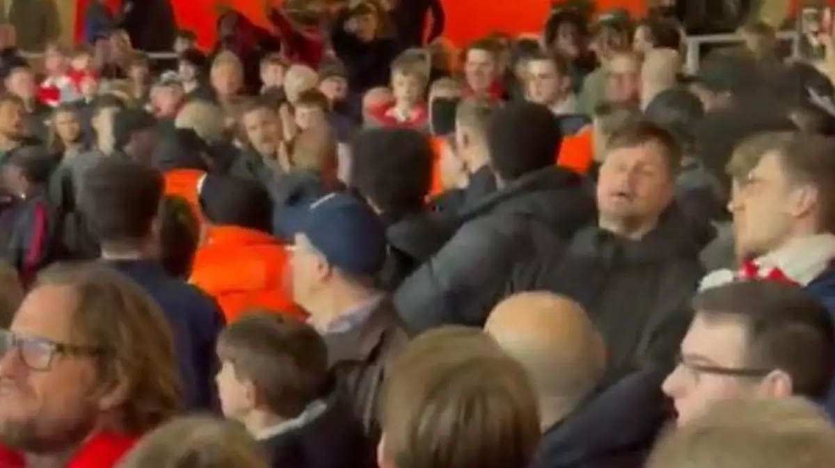 Ein Fußballfan schlägt auf einen anderen ein