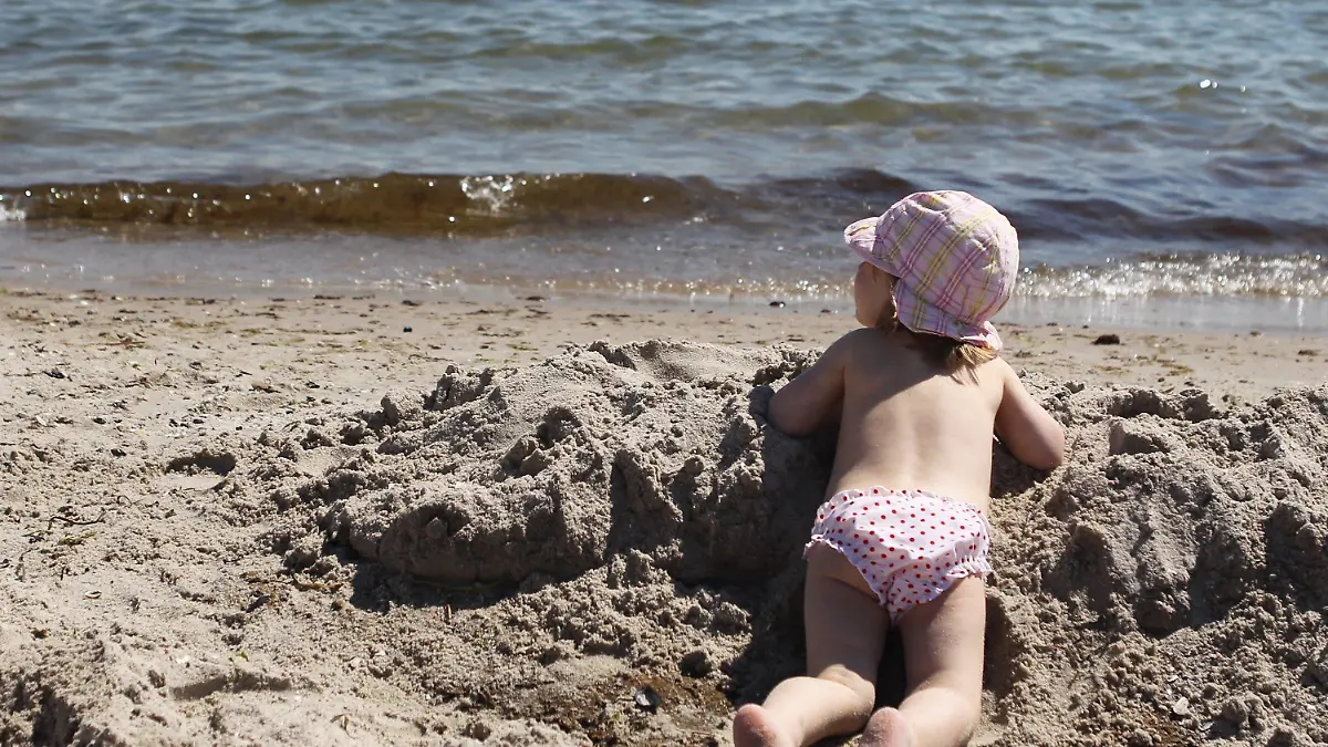 Ein kleines Mädchen spielt am Dienstag (02.08.2011) am Strand von Grömitz. Bei Temperaturen bis zu 24 Grad Celsius und einer Wassertemperatur von 19 Grad Celsius genießen viele Menschen den Tag am Strand. Foto: Malte Christians dpa/lno +++(c) dpa - Bildfunk+++