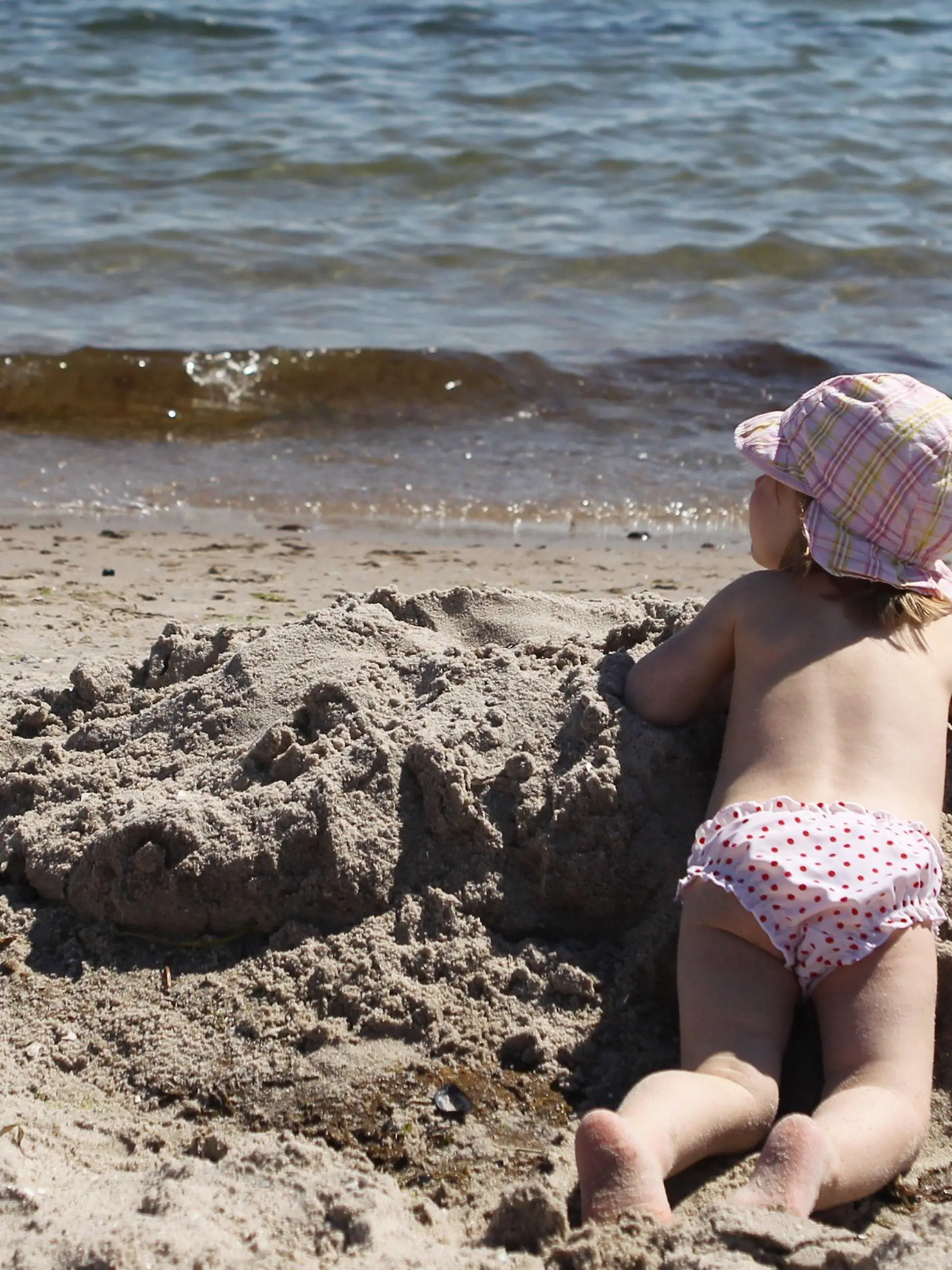 Ein kleines Mädchen spielt am Dienstag (02.08.2011) am Strand von Grömitz. Bei Temperaturen bis zu 24 Grad Celsius und einer Wassertemperatur von 19 Grad Celsius genießen viele Menschen den Tag am Strand. Foto: Malte Christians dpa/lno  +++(c) dpa - Bildfunk+++