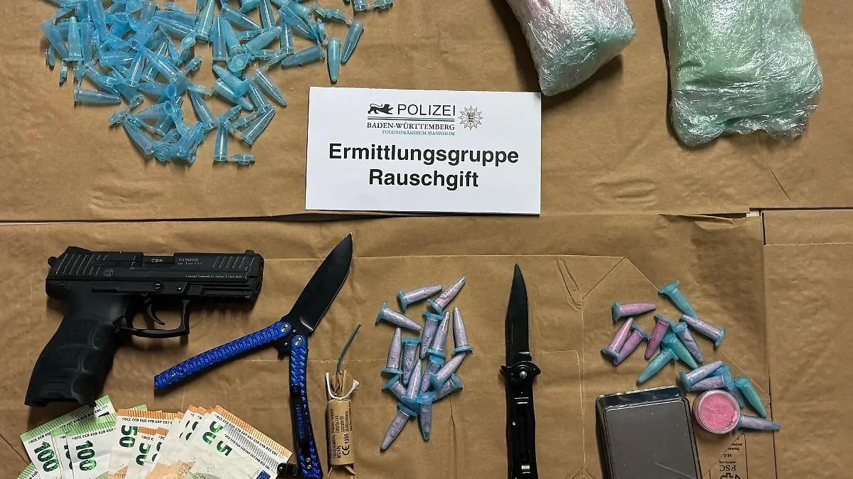 Drogen auf einem Tisch, daneben eine Pistole und Bargeld.