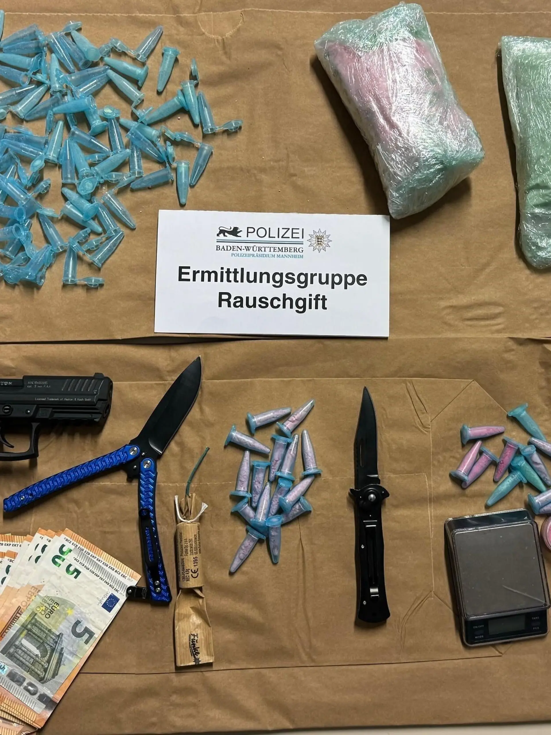 Drogen auf einem Tisch, daneben eine Pistole und Bargeld.