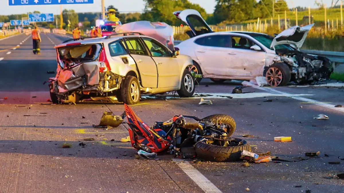 28.08.2022, Brandenburg, Mühlenbecker Land: Ein zerstörtes Motorrad und zwei völlig demolierte Autos stehen nach einem schweren Unfall auf der Autobahn 10. Bei dem Unfall auf der Autobahn 10 nahe der Gemeinde Mühlenbecker Land ist ein Motorradfahrer gestorben, zwei weitere Menschen haben Verletzungen erlitten. Der Unfall ereignete sich zwischen der Anschlussstelle Mühlenbeck und dem Dreieck Pankow, nördlich von Berlin. Foto: Philipp Neumann/TNN/dpa +++ dpa-Bildfunk +++