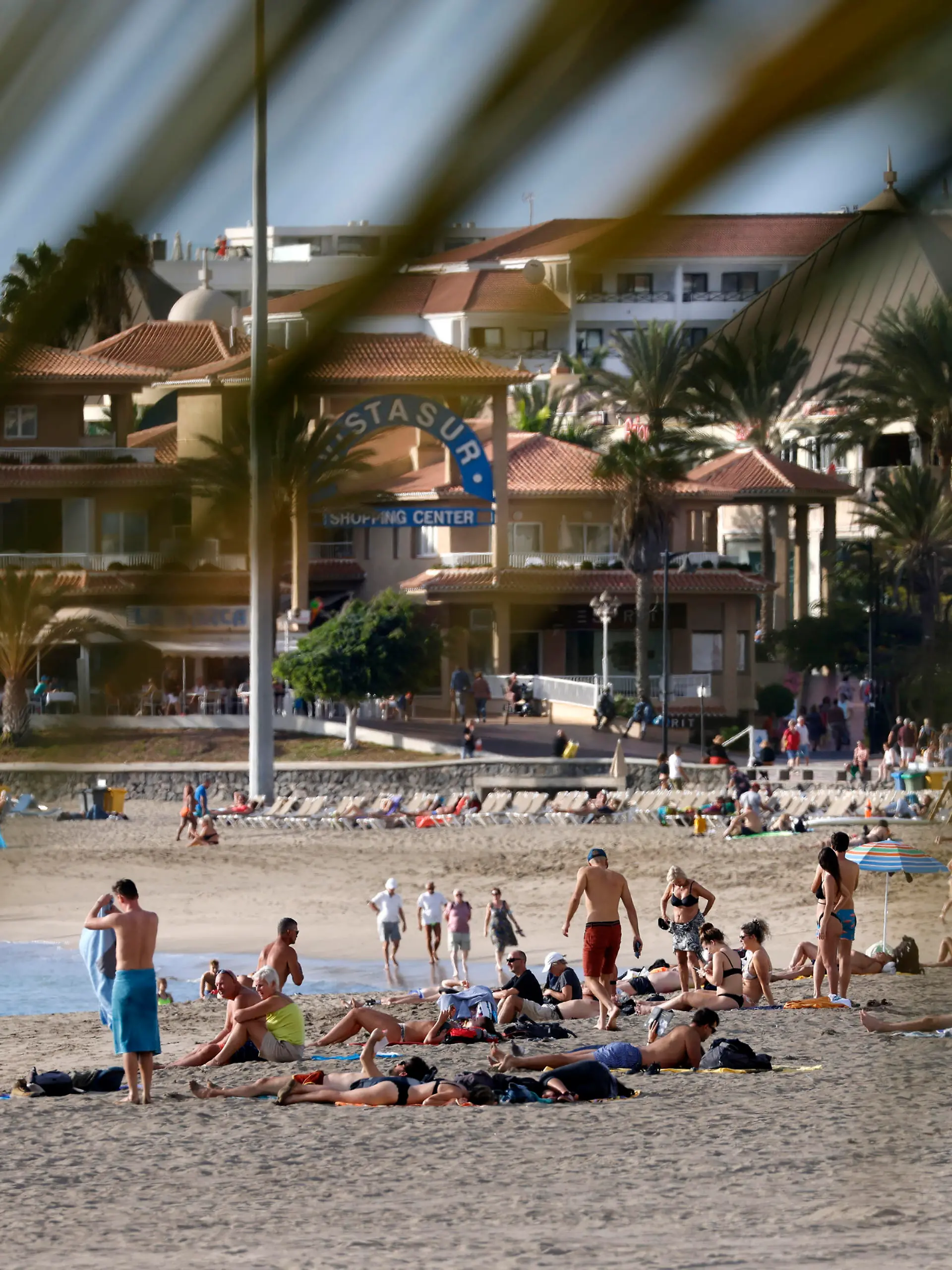 Die Uferpromenade von Los Cristianos auf Teneriffa ist ein bliebtes Urlaubergebiet. Vor der Küste ankern Segelschiffe, am Strand sonnen sich die Badegäste und in den Restaurants und Bars sind vor allem viele Touristen aus Großbritannien anzutreffen. Los Cristianos, 18.11.2021