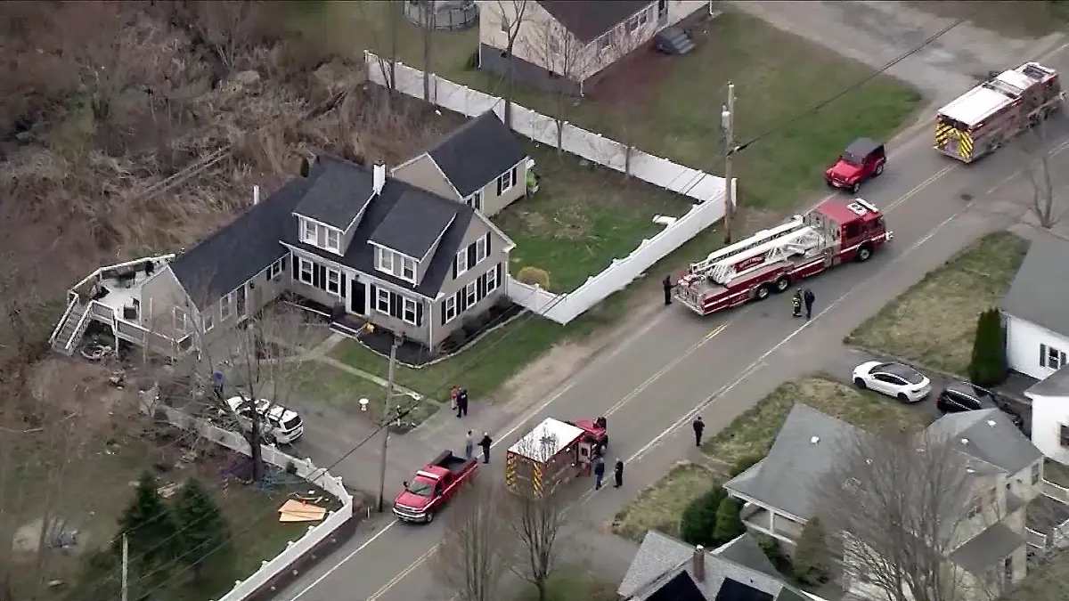 Feuerwehrautos stehen vor einem braunen Haus.