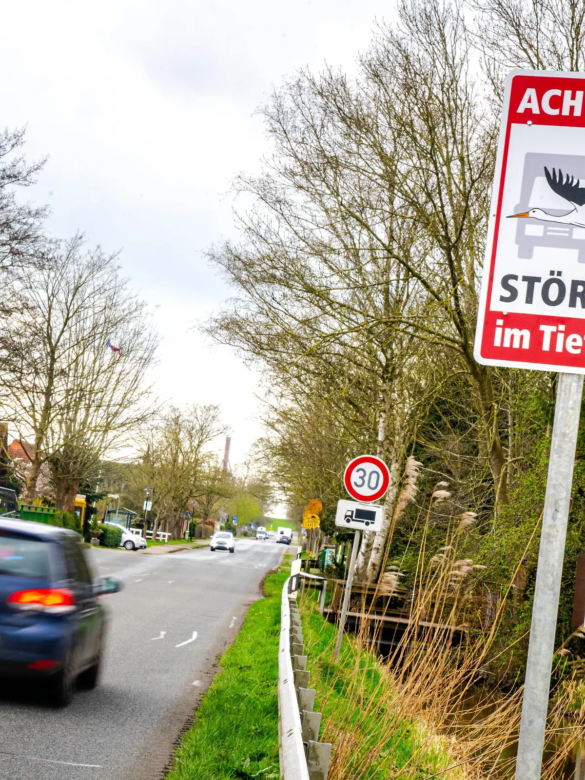 ARCHIV - 02.04.2024, Niedersachsen, Sandstedt: ·Achtung! Störche im Tiefflug· steht auf einem Schild am Ortseingang von Sandstedt im Landkreis Cuxhaven. (zu dpa: «Warnschilder vor tieffliegenden Störchen») Foto: Sina Schuldt/dpa +++ dpa-Bildfunk +++