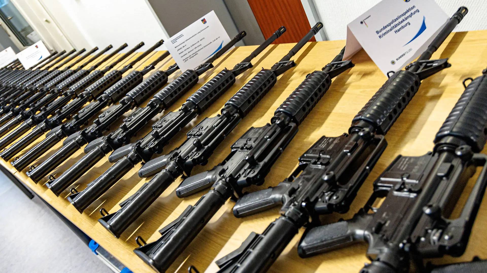 12.04.2024, Hamburg: Sichergestellte Schusswaffen liegen auf einem Tisch in einer Kaserne der Bundespolizei. Die Staatsanwaltschaft Lüneburg und die Bundespolizeidirektion Hannover stellen Details zu Ermittlungen im Fall eines gewerbs- und bandenmäßig begangenen Diebstahls von 40 halbautomatischen Schusswaffen vor. Diese wurden während eines Transports mit der Bahn gestohlen und inzwischen sichergestellt. Foto: Markus Scholz/dpa +++ dpa-Bildfunk +++