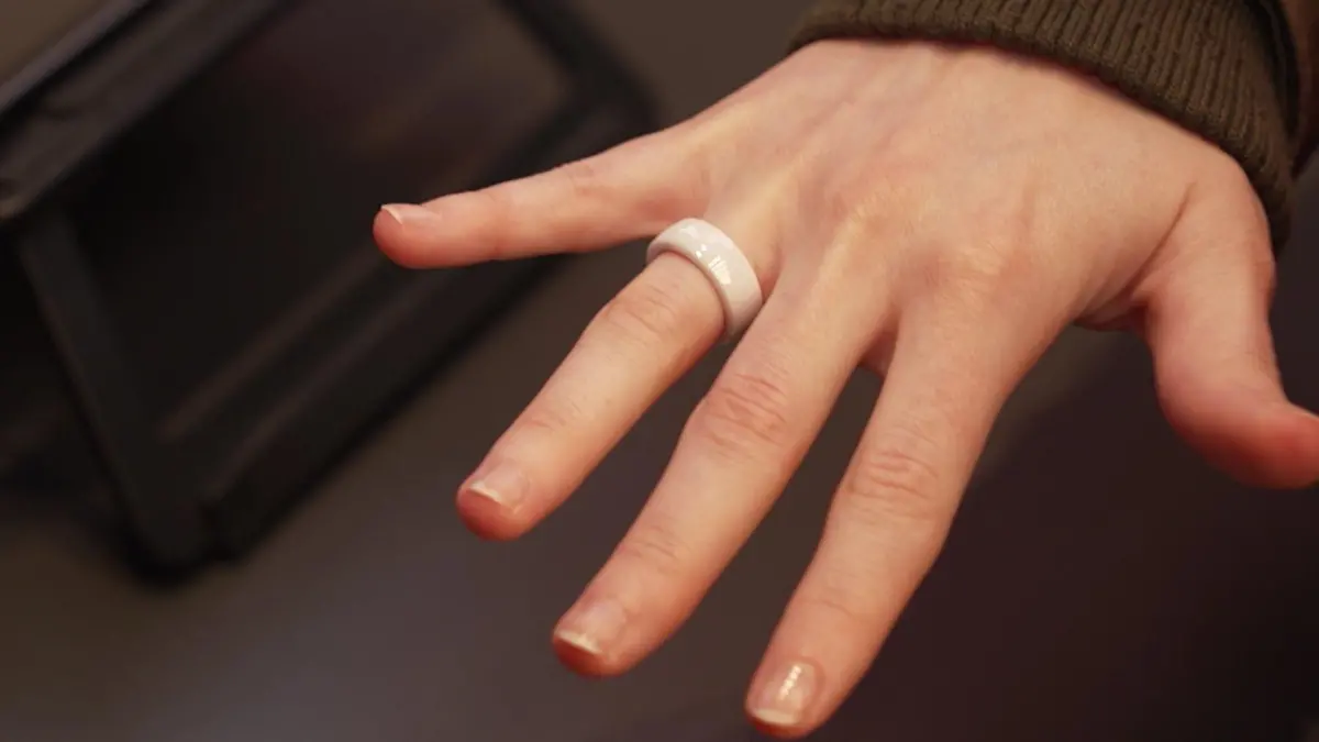 Auf einer Hand sitzt ein weißer Ring.