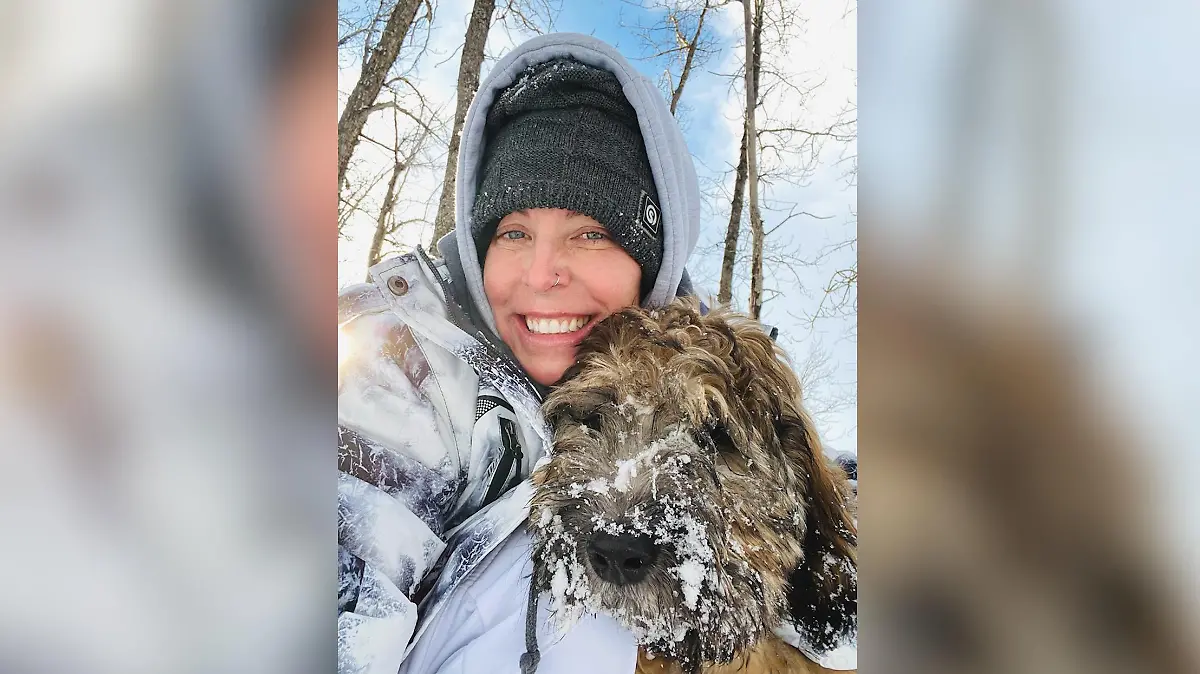 Eine Frau und ein Hund im Arm.