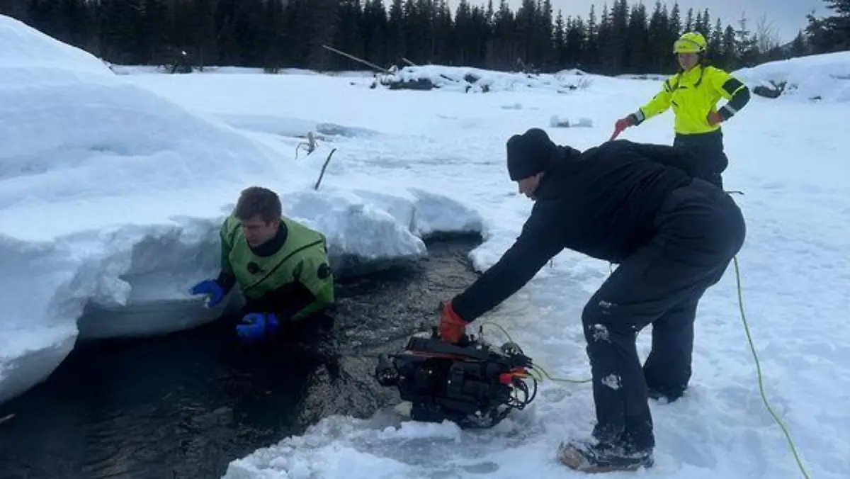 Menschen graben im Schnee nach einem Menschen mit Hund.