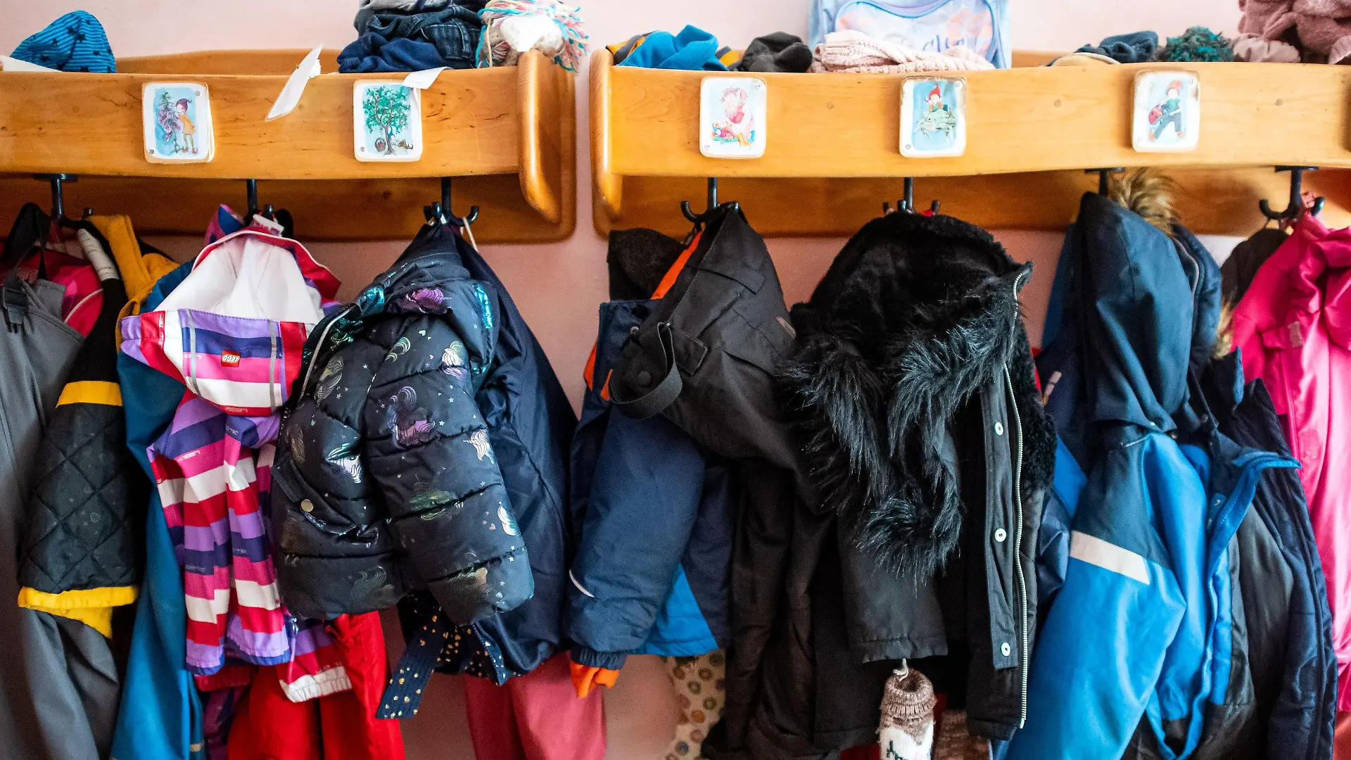 08.03.2021, Niedersachsen, Delmenhorst: Kinderjacken und Rucksäcke hängen an der Garderobe in einer Kita. In Regionen, deren Sieben-Tage-Wert an drei aufeinanderfolgenden Tagen unter 100 Neuinfektionen pro 100 000 Einwohner liegt, kehren die Kitas in den eingeschränkten Regelbetrieb zurück. Foto: Sina Schuldt/dpa +++ dpa-Bildfunk +++