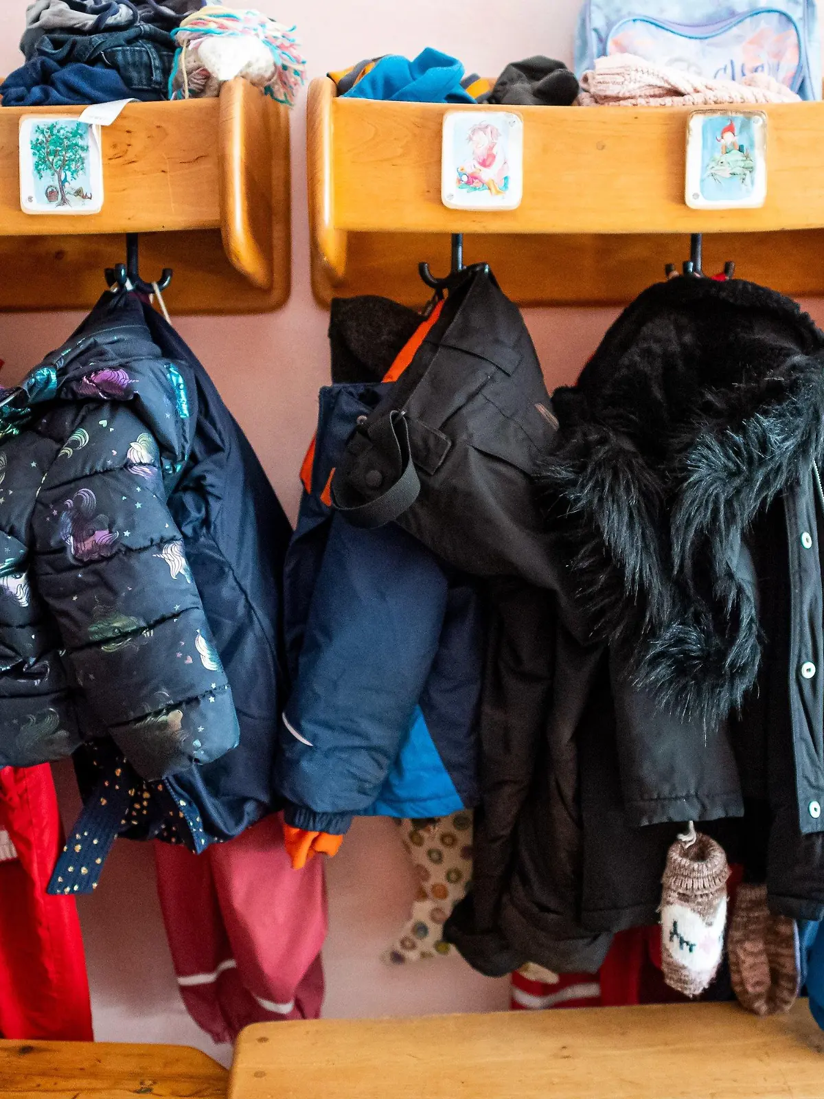 08.03.2021, Niedersachsen, Delmenhorst: Kinderjacken und Rucksäcke hängen an der Garderobe in einer Kita. In Regionen, deren Sieben-Tage-Wert an drei aufeinanderfolgenden Tagen unter 100 Neuinfektionen pro 100 000 Einwohner liegt, kehren die Kitas in den eingeschränkten Regelbetrieb zurück. Foto: Sina Schuldt/dpa +++ dpa-Bildfunk +++