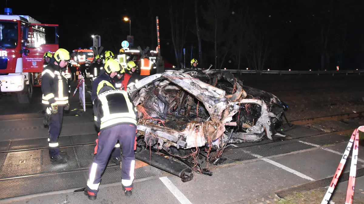 12.04.2024, Brandenburg, Bestensee: Rettungskräfte stehen am Wrack eines zerstörten Autos nach einem Unfall an einem Bahnübergang. Ein Mensch ist beim Zusammenstoß eines Autos mit einem Zug an einem Bahnübergang in Bestensee (Landkreis Dahme-Spreewald) ums Leben gekommen. Foto: Christian Sappeck/BLP/dpa +++ dpa-Bildfunk +++
