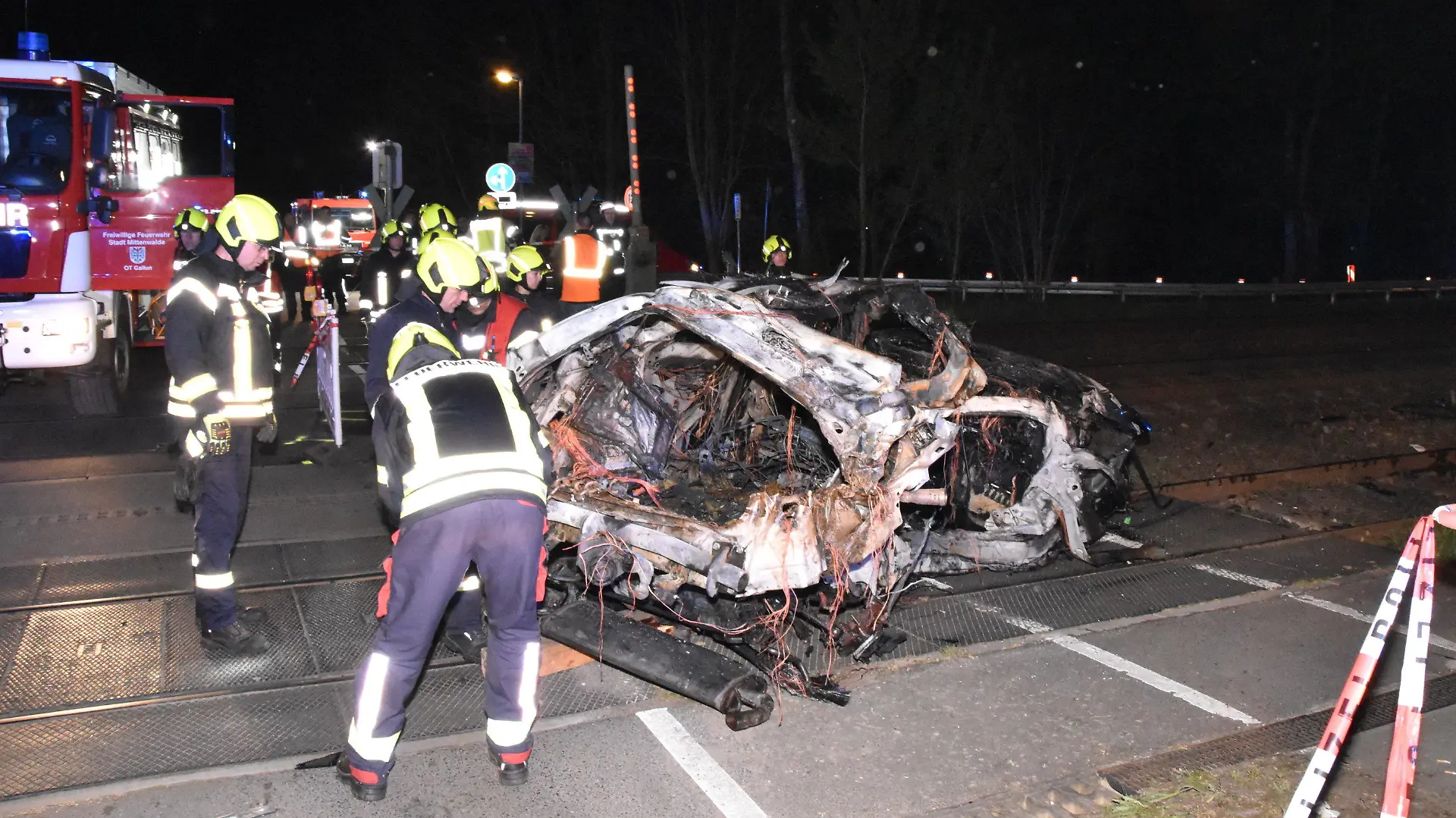 12.04.2024, Brandenburg, Bestensee: Rettungskräfte stehen am Wrack eines zerstörten Autos nach einem Unfall an einem Bahnübergang. Ein Mensch ist beim Zusammenstoß eines Autos mit einem Zug an einem Bahnübergang in Bestensee (Landkreis Dahme-Spreewald) ums Leben gekommen. Foto: Christian Sappeck/BLP/dpa +++ dpa-Bildfunk +++