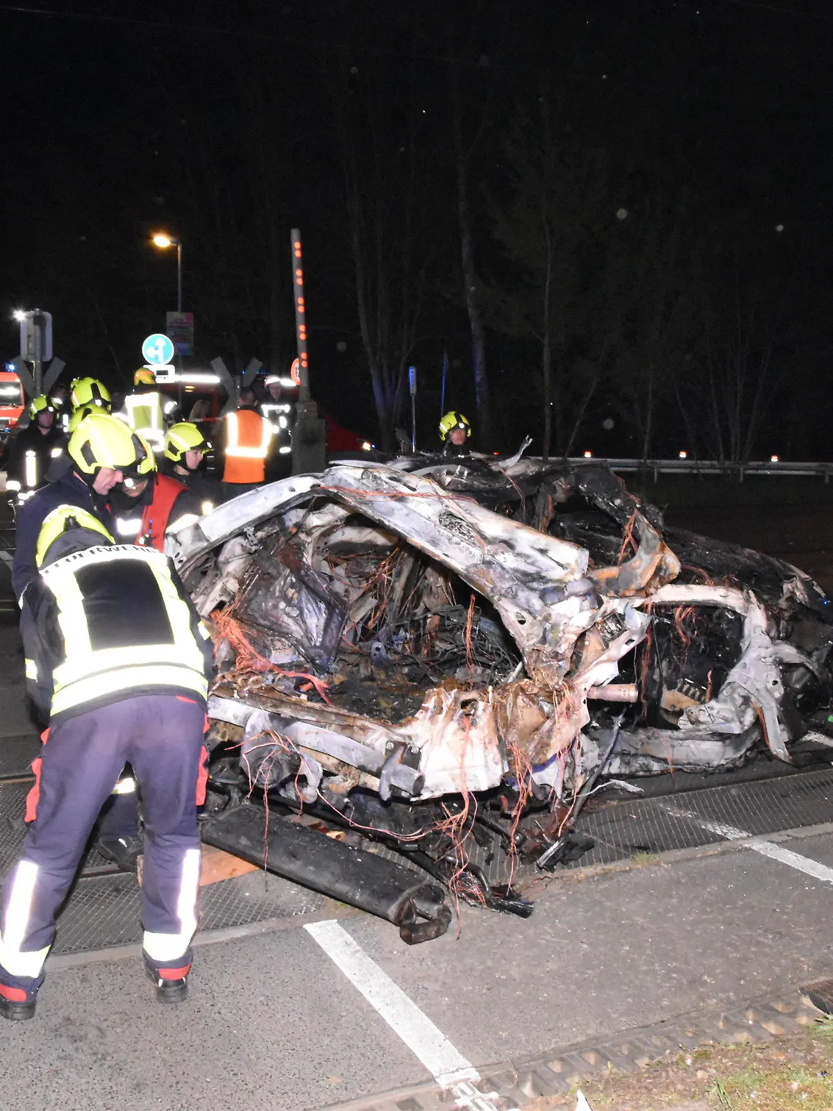 12.04.2024, Brandenburg, Bestensee: Rettungskräfte stehen am Wrack eines zerstörten Autos nach einem Unfall an einem Bahnübergang. Ein Mensch ist beim Zusammenstoß eines Autos mit einem Zug an einem Bahnübergang in Bestensee (Landkreis Dahme-Spreewald) ums Leben gekommen. Foto: Christian Sappeck/BLP/dpa +++ dpa-Bildfunk +++