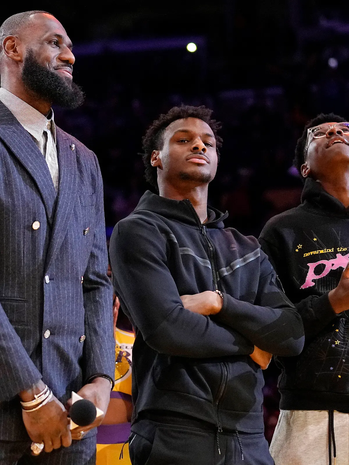 FILE - Los Angeles Lakers forward LeBron James, second from left, Bronny James, center, and Bryce James stand during a ceremony honoring LeBron James as the NBA's all-time leading scorer, before the Lakers' basketball game against the Milwaukee Bucks on Feb. 9, 2023, in Los Angeles. Bronny James was hospitalized in stable condition Tuesday, July 25, 2023, a day after going into cardiac arrest while participating in a practice at the University of Southern California, a family spokesman said. (AP Photo/Mark J. Terrill)