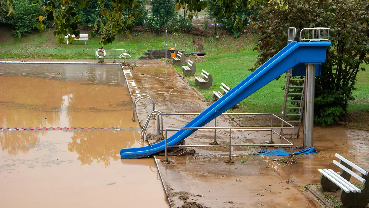 27.08.2022, Sachsen, Gersdorf: Eine Schlammlawine hat das Freibad verwüstet - der Schlamm steht einen halben Meter hoch im Becken. Seit Freitagmittag waren immer wieder kräftige Gewitter über Sachsen gezogen, die örtlich unwetterartigen Regen brachten. Foto: Maxim Schaller ID 667/Blaulichtreport&Stormchasing/dpa +++ dpa-Bildfunk +++