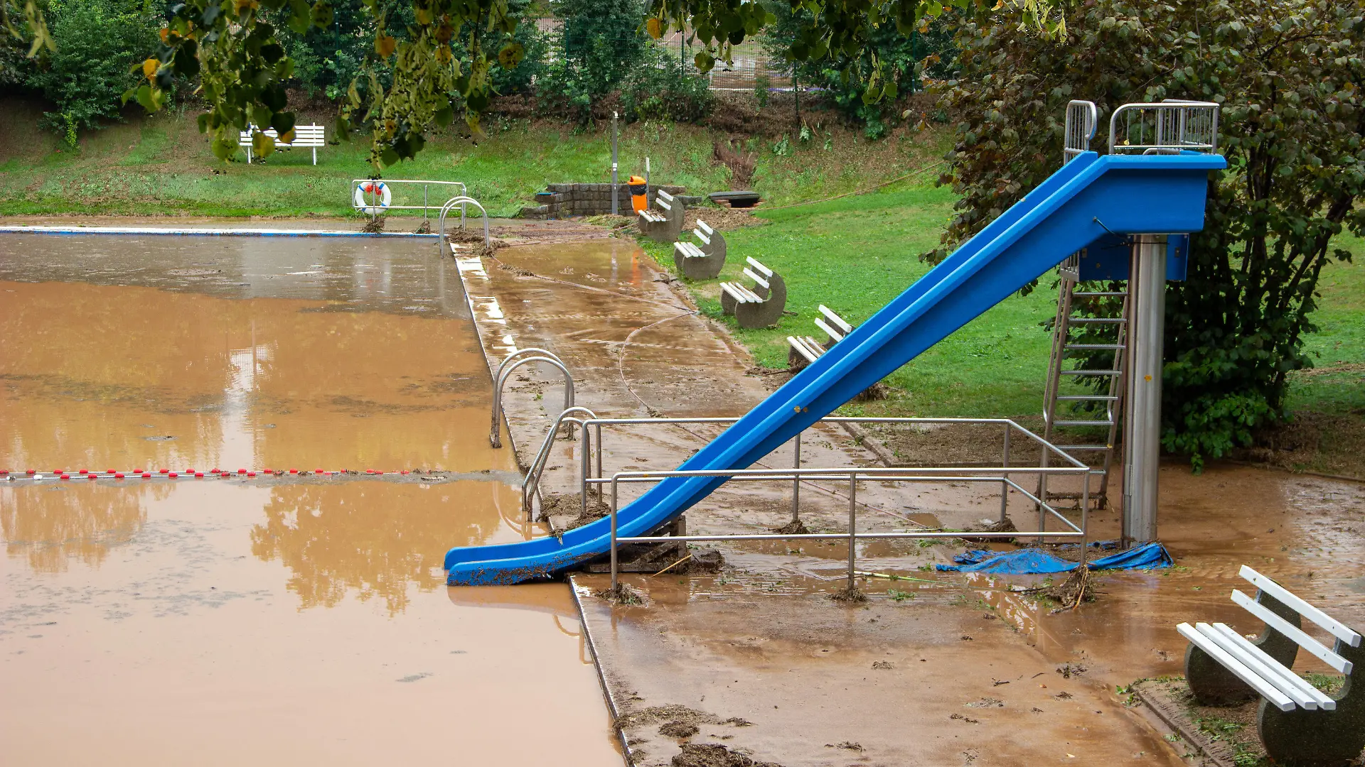 27.08.2022, Sachsen, Gersdorf: Eine Schlammlawine hat das Freibad verwüstet - der Schlamm steht einen halben Meter hoch im Becken. Seit Freitagmittag waren immer wieder kräftige Gewitter über Sachsen gezogen, die örtlich unwetterartigen Regen brachten. Foto: Maxim Schaller ID 667/Blaulichtreport&Stormchasing/dpa +++ dpa-Bildfunk +++