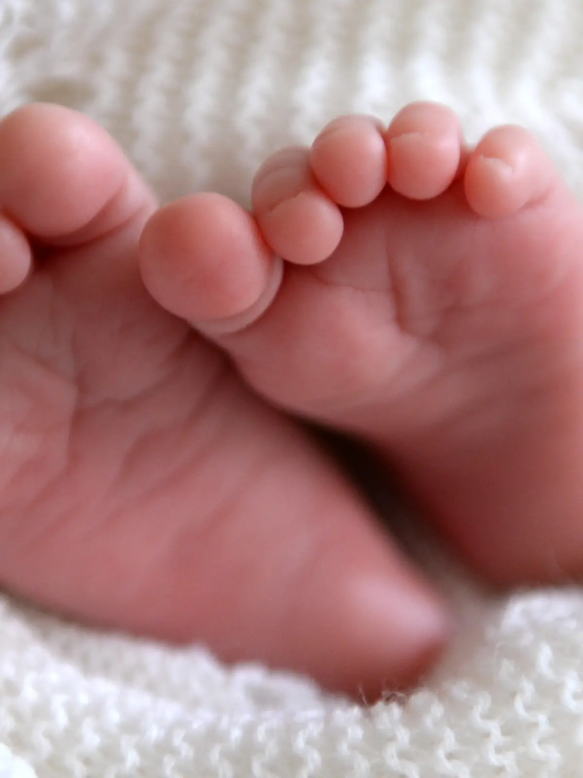 Parents who co-sleep with babies. File photo dated 11/07/2014 of a new born baby's feet are visible peeking out of a shawl. Leading experts are calling for parents to be given safety advice about co-sleeping with their babies after research revealed that most do it at some point. A poll of 3,402 new parents for the charity Lullaby Trust, which raises awareness of sudden infant death syndrome (SIDS), found nine in 10 parents have slept alongside their baby, but only four in 10 have been advised by a health professional how to reduce the risk of cot death. Issue date: Monday March 13, 2023. See PA story HEALTH Sleeping. Photo credit should read: Andrew Matthews/PA Wire URN:71358893