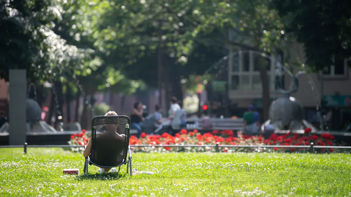 18.06.2021, Rheinland-Pfalz, Mainz: Ein Mann sonnt sich in einem Park. (zu dpa "Mainzer dürfen Sehnsucht nach Sommer ausleben") Foto: Sebastian Gollnow/dpa +++ dpa-Bildfunk +++
