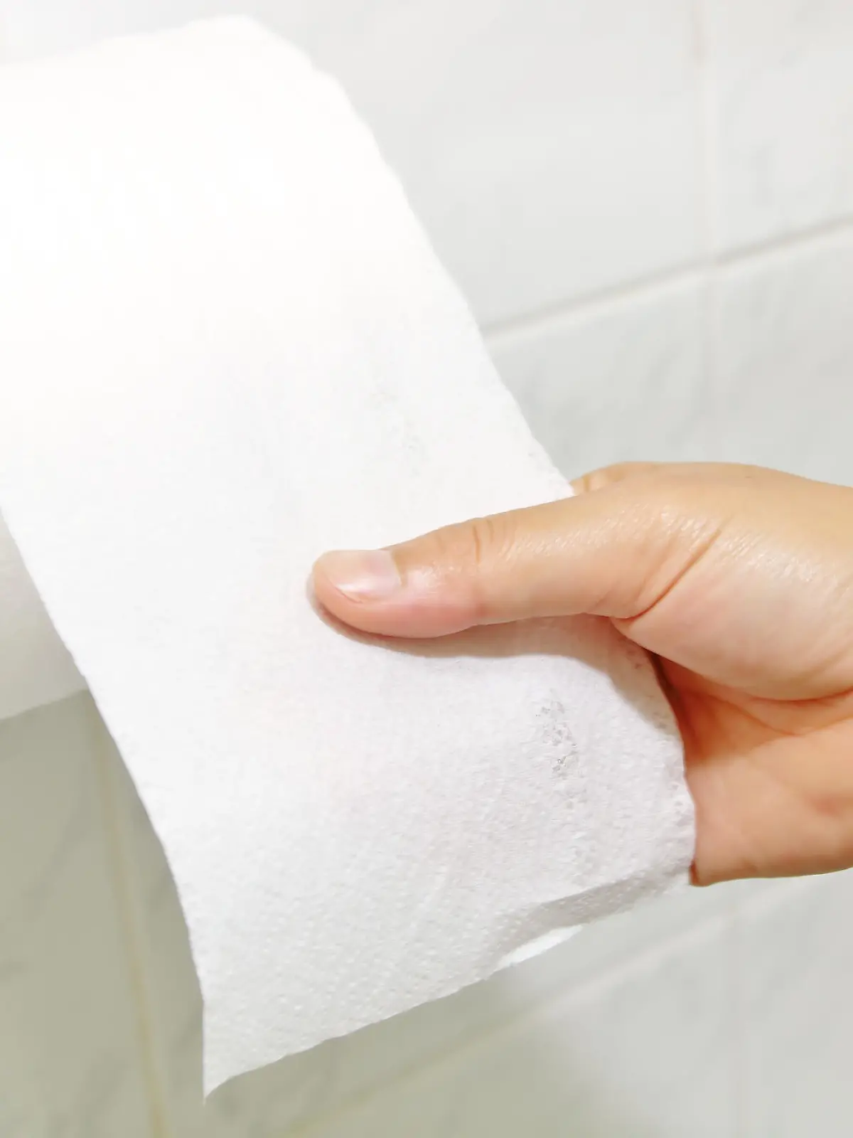 Woman hand holding the roll of toilet paper
