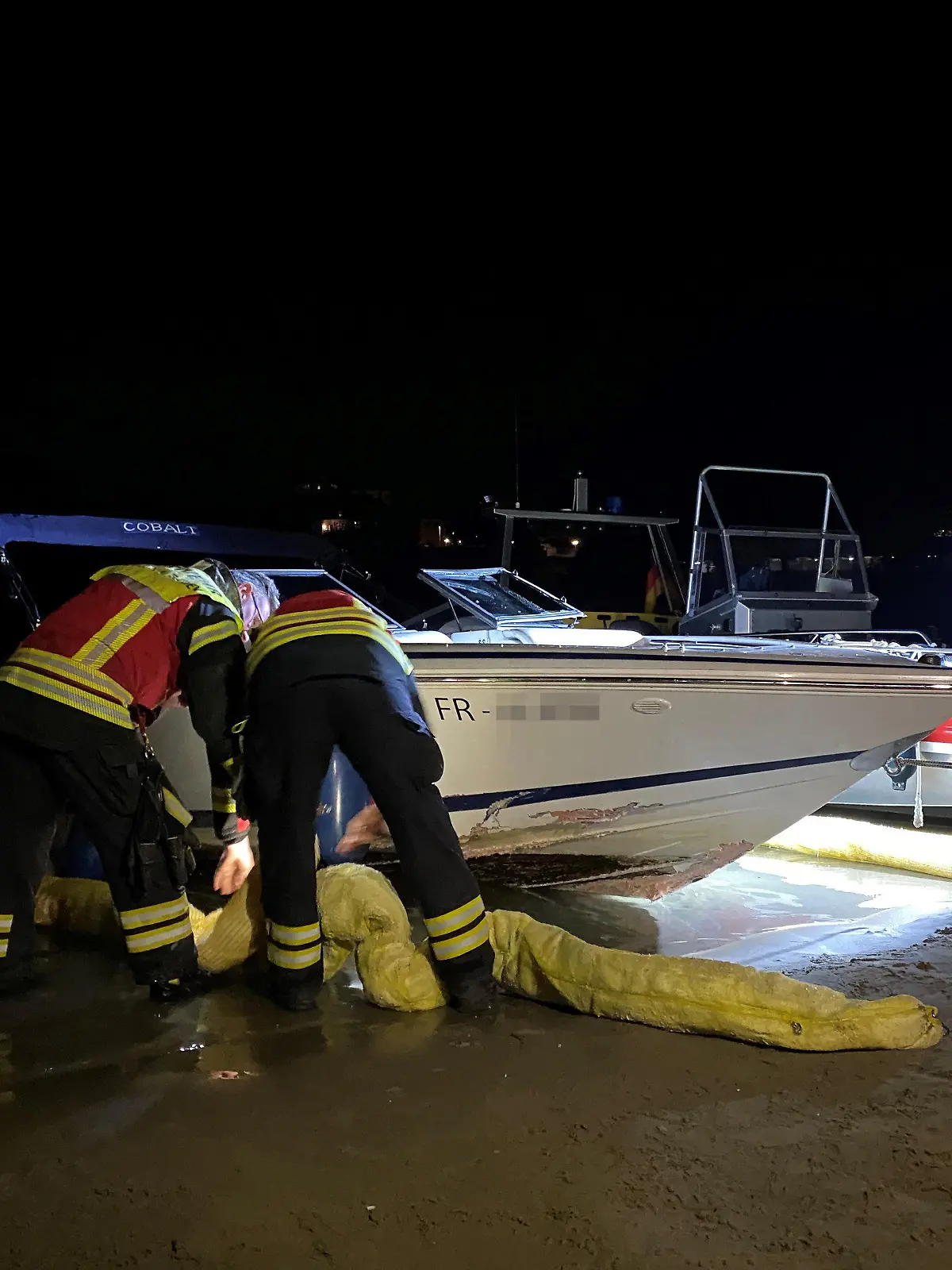 HANDOUT - 25.08.2022, Schweiz, Rheinfelden: Feuerleute untersuchen das havarierte Boot. Eine 33-jährige Frau aus Deutschland ist bei einem Bootsunfall auf dem Rhein ums Leben gekommen. Wie die Schweizer Polizei am 26.08.2022 berichtete, krachte das Sportboot am Vorabend bei Rheinfelden gegen eine Mauer. Die vier Insassen, die alle in Deutschland lebten, seien ins Wasser gefallen, hieß es. Die Feuerwehren der Schweizer Grenzstadt Rheinfelden und der baden-württembergischen Nachbarstadt Rheinfelden suchten mit anderen Rettungseinheiten in der Dunkelheit nach den Opfern. Die 33-Jährige war bei ihrer Bergung nicht mehr ansprechbar und konnte nicht mehr wiederbelebt werden. Foto: Kantonspolizei Aargau/dpa - ACHTUNG: Nur zur redaktionellen Verwendung im Zusammenhang mit der aktuellen Berichterstattung und nur mit vollständiger Nennung des vorstehenden Credits +++ dpa-Bildfunk +++
