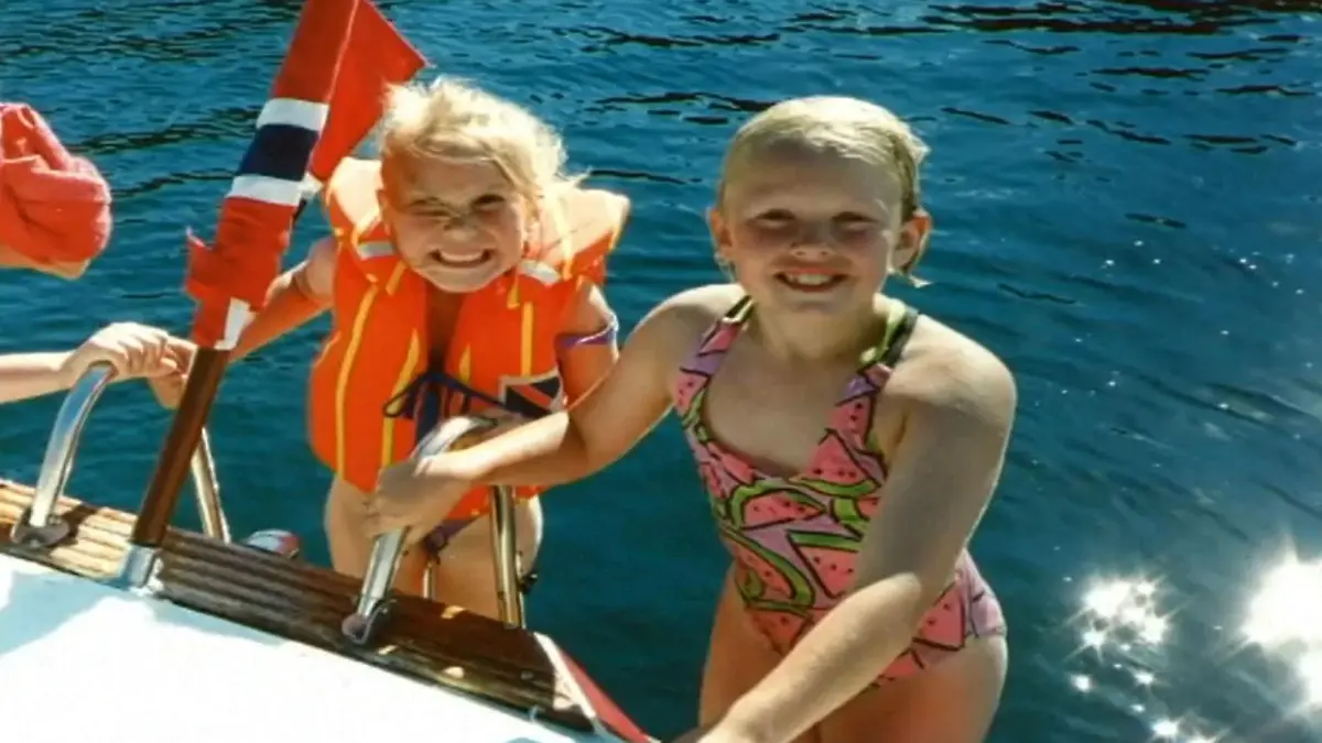 Zwei Mädchen in Schwimmsachen auf einem Boot.