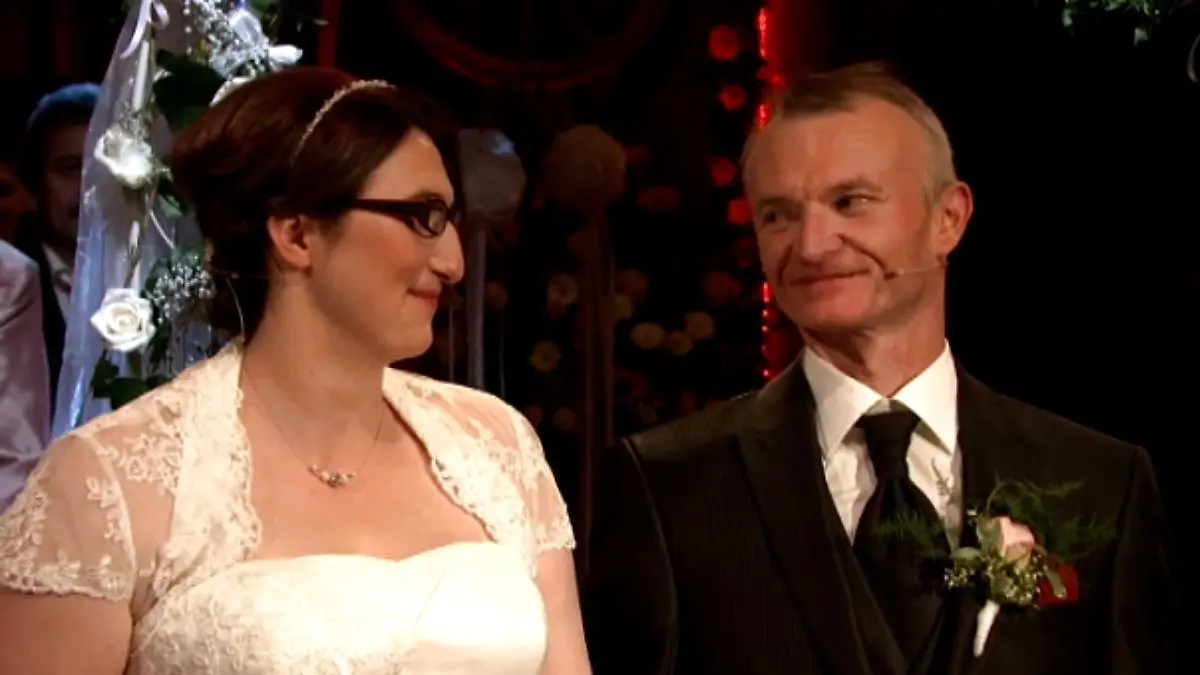 Tanja und Jürgen stehen vor dem Altar und sehen sich verliebt an.