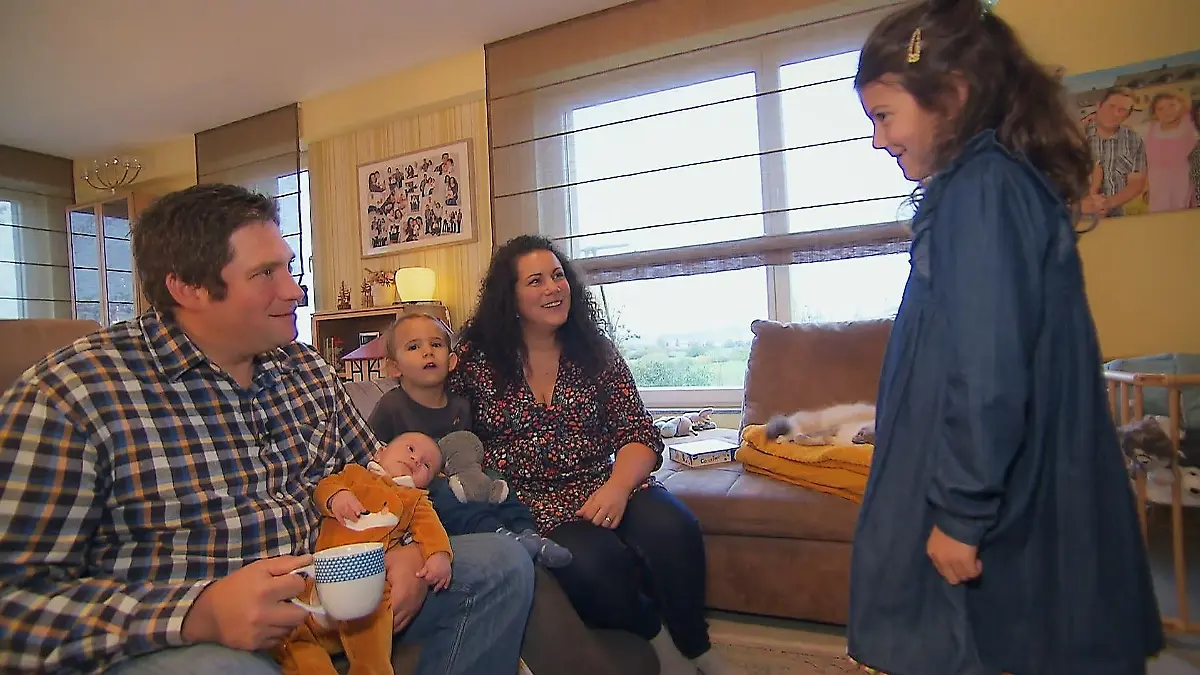 Victoria und Guy sitzen mit allen Kindern auf der Couch.