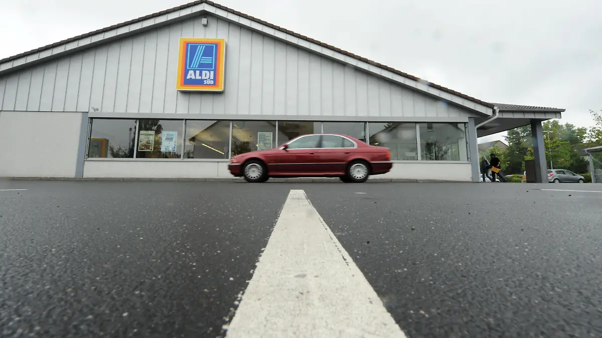 Ein Auto fährt am Montag (16.08.2010) in Frankfurt am Main vom Parkplatz einer Filiale des Discounters Aldi Süd weg. Europas größter Versicherungskonzern Allianz will Immobilien des Discounters Aldi Süd kaufen. Foto: Arne Dedert dpa/lhe