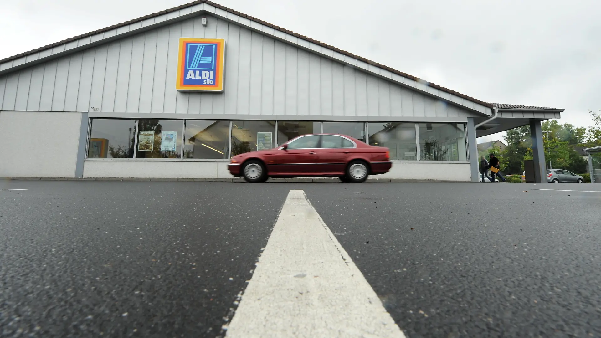 Ein Auto fährt am Montag (16.08.2010) in Frankfurt am Main vom Parkplatz einer Filiale des Discounters Aldi Süd weg. Europas größter Versicherungskonzern Allianz will Immobilien des Discounters Aldi Süd kaufen. Foto: Arne Dedert dpa/lhe