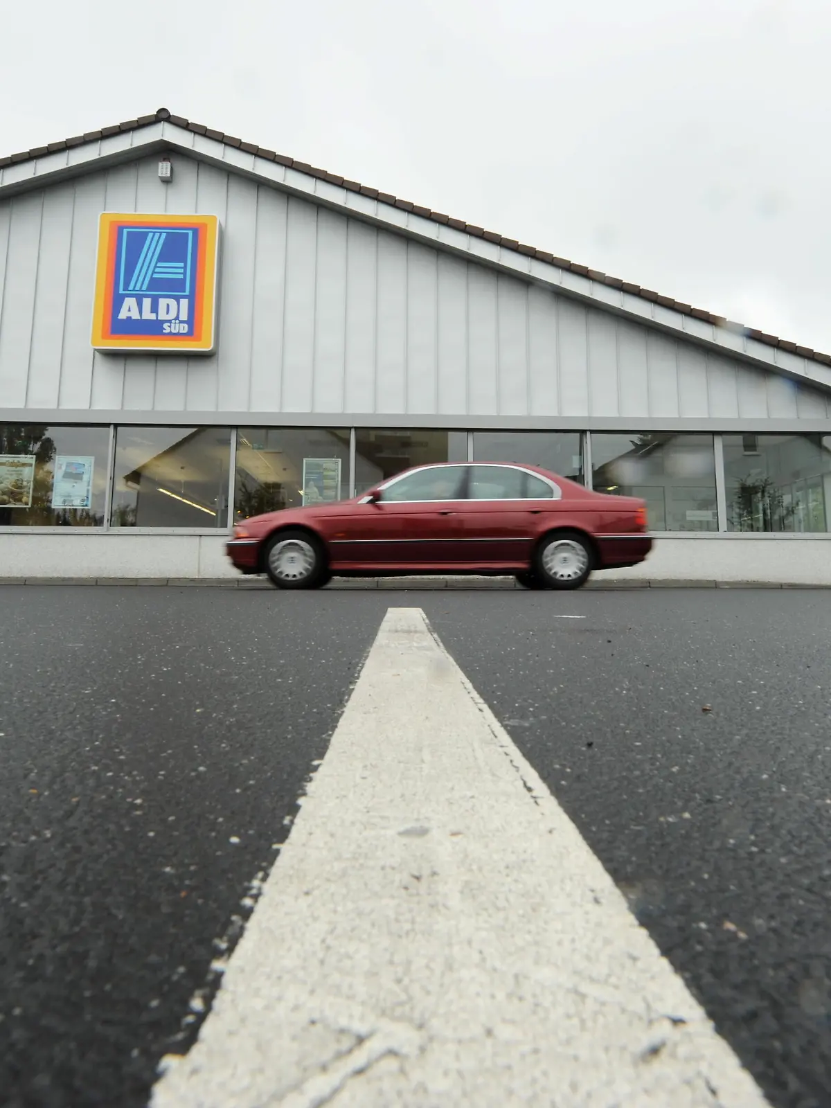 Ein Auto fährt am Montag (16.08.2010) in Frankfurt am Main vom Parkplatz einer Filiale des Discounters Aldi Süd weg. Europas größter Versicherungskonzern Allianz will Immobilien des Discounters Aldi Süd kaufen. Foto: Arne Dedert dpa/lhe