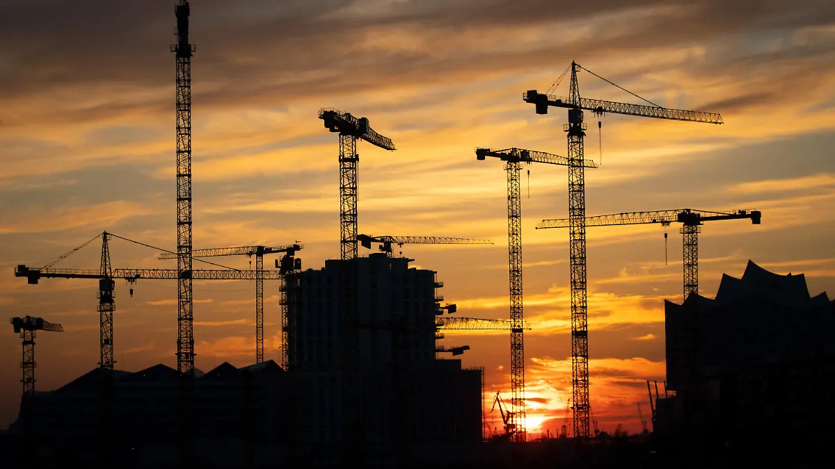 ARCHIV - 25.03.2020, Hamburg: Die Kräne verschiedener Baustellen in der Hafencity zeichnen sich im Sonnenuntergang ab. Wie sich die Finanzen von Bund, Ländern, Gemeinden und Sozialversicherung im ersten Halbjahr 2022 entwickelt haben, gibt das Statistische Bundesamt am Donnerstag bekannt. (zu dpa «Statistiker geben Daten zu Staatshaushalt und Konjunktur bekannt») Foto: Christian Charisius/dpa +++ dpa-Bildfunk +++