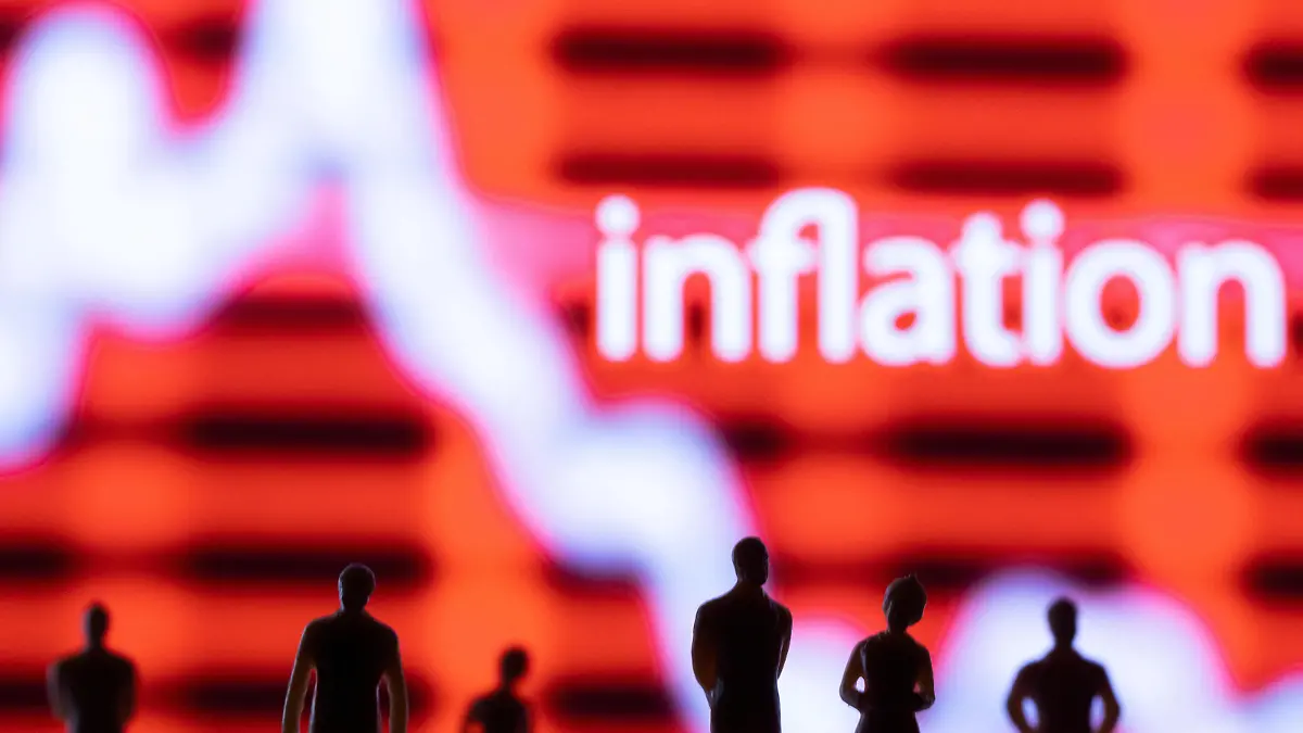 FILE PHOTO: Figurines are seen in front of displayed stock graph and word "Inflation" in this illustration taken June 13, 2022. REUTERS/Dado Ruvic/Illustration/File Photo