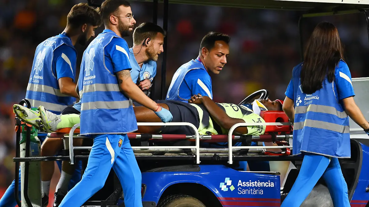 BARCELONA, SPAIN - AUGUST 24: Luke Mbete-Tabu of Manchester City is stretched off after picking up a injury during the friendly match between FC Barcelona and Manchester City at Camp Nou on August 24, 2022 in Barcelona, Spain. (Photo by David Ramos/Getty Images)