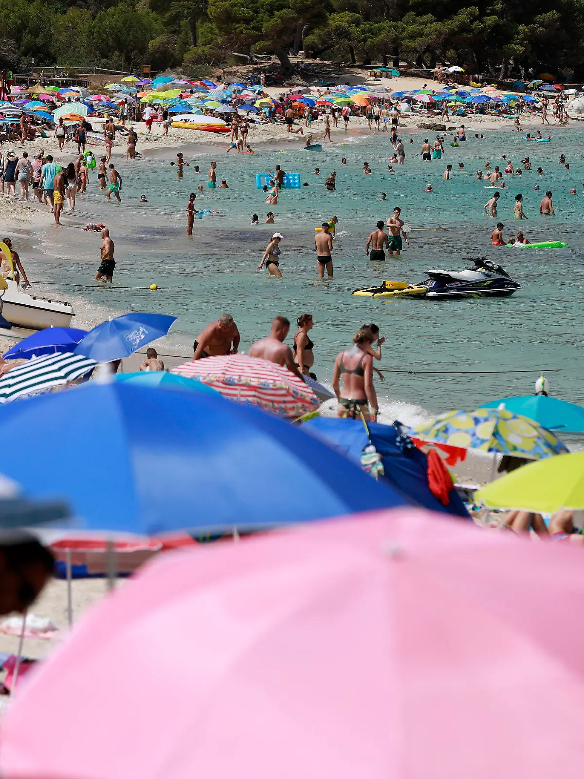 14.08.2022, Spanien, Capdepera: Menschen schwimmen und sonnen sich am Strand Cala Agulla nahe Cala Rajada auf Mallorca. Noch immer herrschen hier hohe Temperaturen und Hitzewarnungen. Foto: Clara Margais/dpa +++ dpa-Bildfunk +++