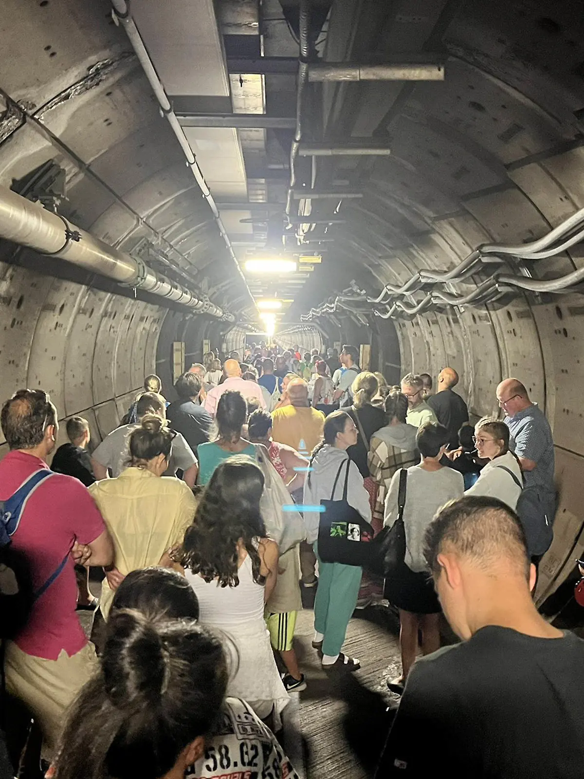 23.08.2022, ---: Handout-Bild mit Genehmigung des Twitter-Feeds von Kate Scott von Fahrgästen in einem Nottunnel des Eurotunnel zwischen Frankreich und England. Nach der Panne eines der Züge mussten Passagiere im Tunnel ihre Wagen verlassen und wurden zu Fuß durch den Nottunnel begleitet. Sie sollen mit einem Shuttle zum Bahnhof Folkestone zurück gebracht werden. Der Eurotunnel ist ein gut 50 Kilometer langer Eisenbahntunnel unter dem Ärmelkanal. Foto: Kate Scott/Twitter/PA Media/dpa - ACHTUNG: Nur zur redaktionellen Verwendung. +++ dpa-Bildfunk +++