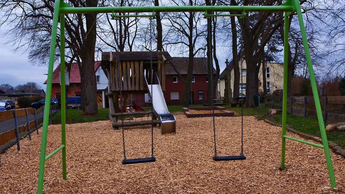 Eine grüne Schaukel auf einem öffentlichen Spielplatz