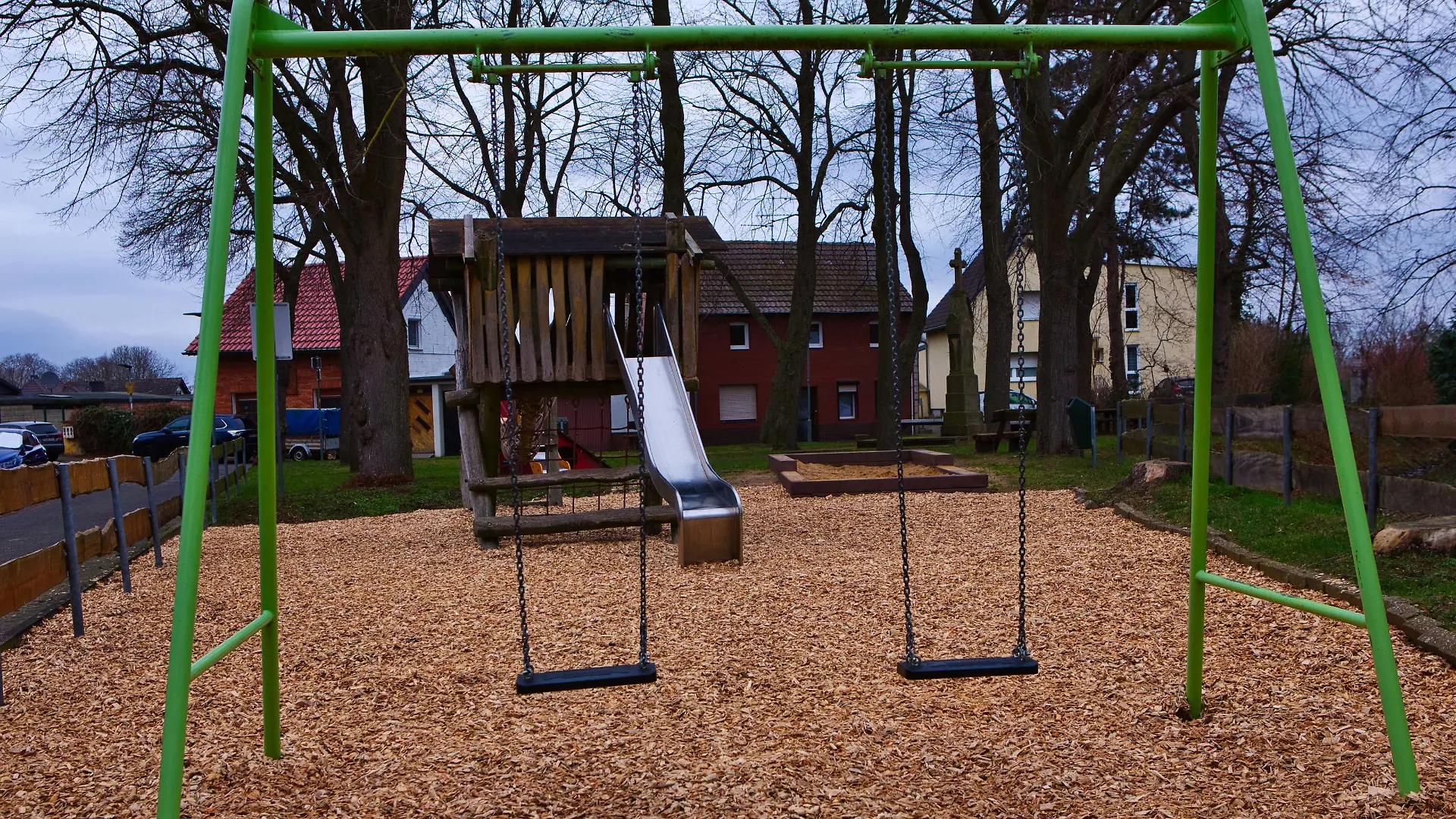 Eine grüne Schaukel auf einem öffentlichen Spielplatz