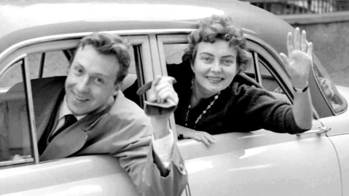 Der Schauspieler, Entertainer und Sänger Peter Alexander und seine Frau Hilde winken aus ihrem Auto bei einer Spritztour durch Wien (Aufnahme vom 25.10.1955). Die Ehefrau und Managerin des österreichischen Schlagersängers ist am 30.3.2003 in Wien an den Folgen eines komplizierten Bruchs gestorben. Am 22. September vergangenen Jahres konnte das Paar noch goldene Hochzeit feiern. Mit Titeln wie "Die kleine Kneipe" wurde Peter Alexander in den 50er und 60er Jahren populär. Mit Filmen wie "Im Weißen Rössl" feierte er auch als Schauspieler große Erfolge.