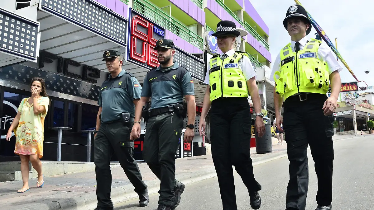 epa04882091 Two British policemen (R and 2-R) and two Spanish Civil Guard officers patrol in the touristic area of Magaluf, in Majorca, Balearic Islands, eastern Spain, 13 August 2015, during the presentation to media of two 'bobbies' Anderson and Williams from West Midlands who are made up of mixed international patrol to watch the foreign tourists. Police officers from Germany, Italy and French will patrol in Balearic Islands during summer. EPA/ALBERTO ATIENZA +++(c) dpa - Bildfunk+++