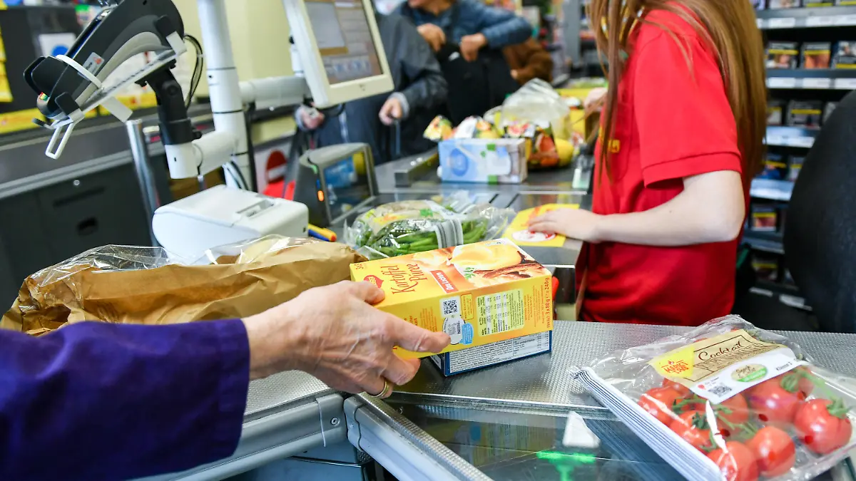 ARCHIV - 18.09.2019, Berlin: Eine Kundin nimmt in einem Supermarkt Waren vom Band an der Kasse, nachdem eine Kassiererin die Waren gescannt hat. Deutsche Verbraucher und Unternehmen müssen sich nach Einschätzung des Ifo-Instituts auf weitere Preiserhöhungen einstellen. (Zu dpa "Ifo: Viele Unternehmen planen Preiserhöhungen") Foto: Jens Kalaene/dpa-Zentralbild/dpa +++ dpa-Bildfunk +++