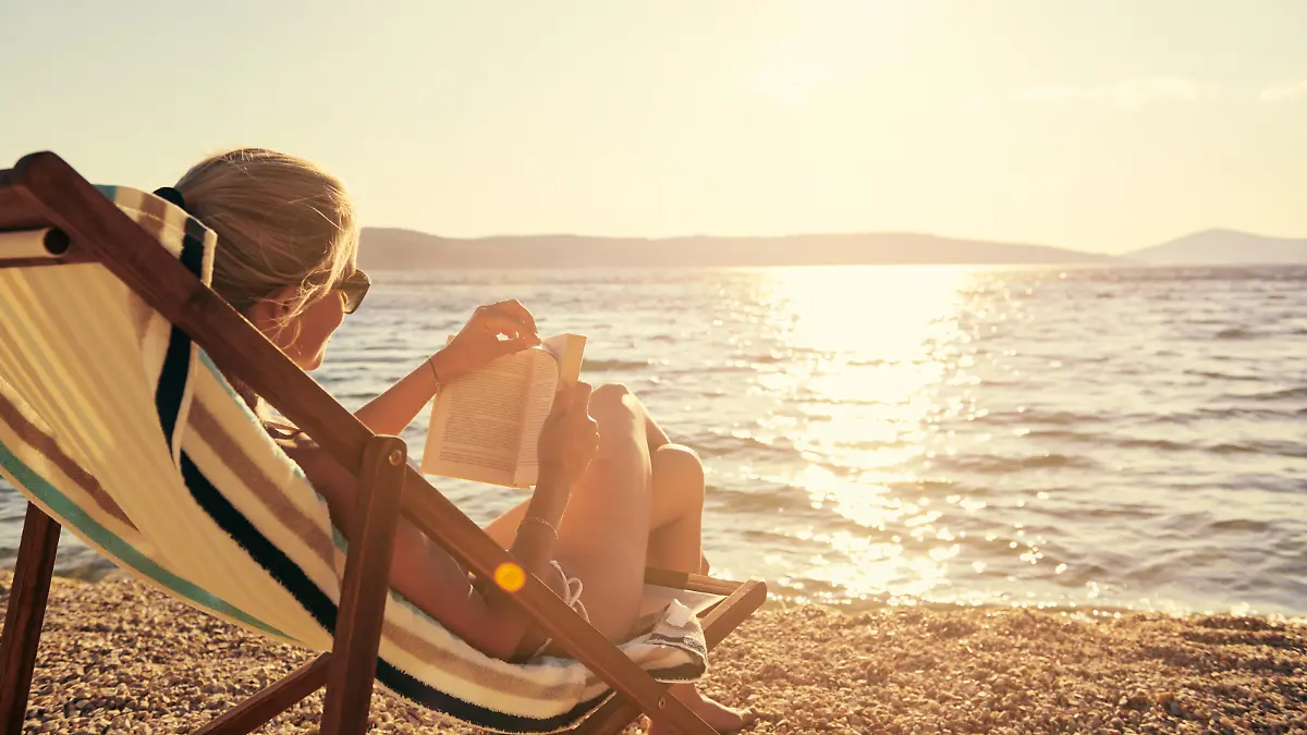 A young woman reading a book while sitting on a chair at the beachhttp://195.154.178.81/DATA/i_collage/pu/shoots/805670.jpg