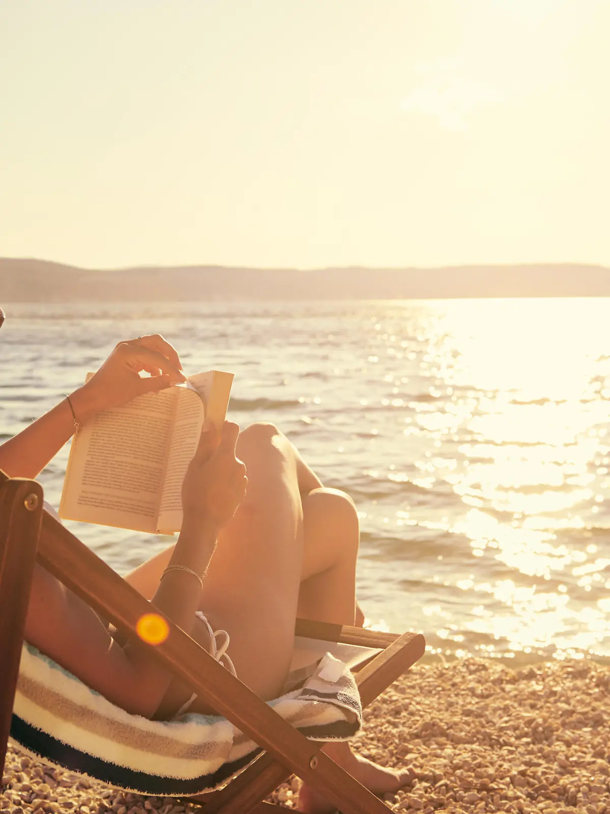 A young woman reading a book while sitting on a chair at the beachhttp://195.154.178.81/DATA/i_collage/pu/shoots/805670.jpg
